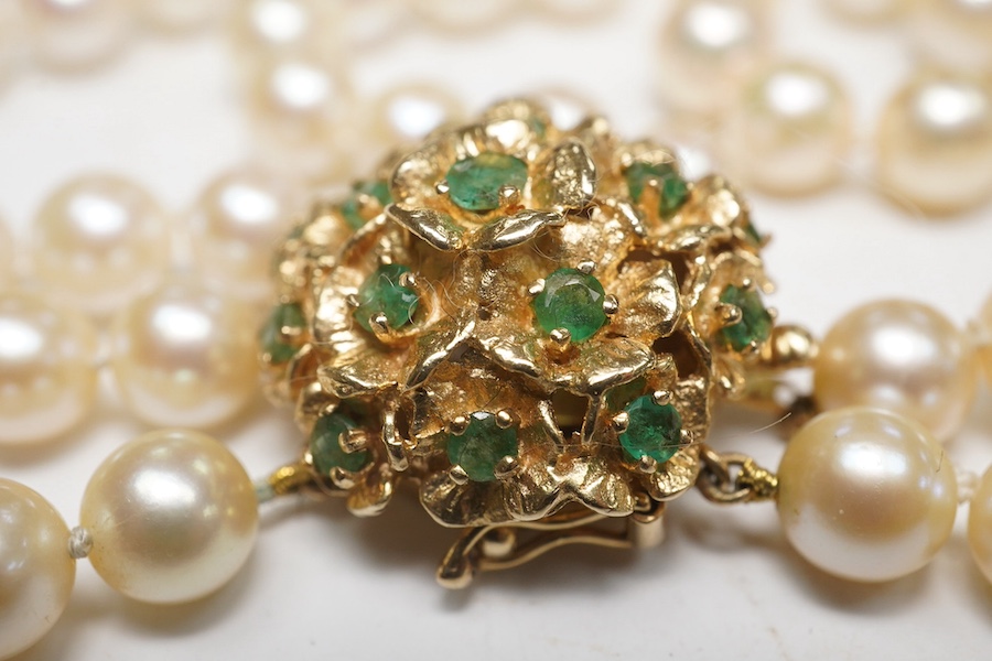 A modern triple strand culture pearl necklace, with emerald cluster set 14k clasp, 48cm. Condition - poor to fair